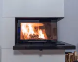 Nowoczesny kominek z płaszczem wodnym, idealny na 100m2, z palącym się ogniem.