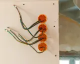 Instalacja elektryczna w domu drewnianym schemat: przewody wychodzące z puszek instalacyjnych w ścianie z płyt gipsowo-kartonowych.