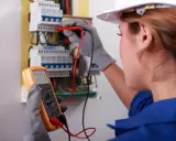 Elektryk sprawdza instalację multimetrem. Dowiedz się, ile kosztują pomiary elektryczne.