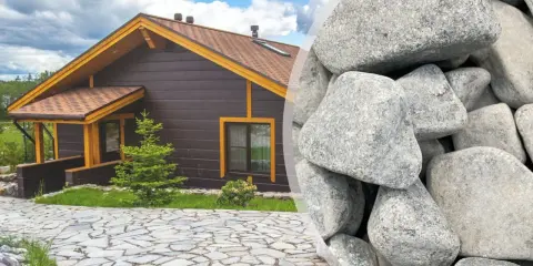 Elegancki podjazd z kamienia prowadzi do przytulnego drewnianego domu. Obok widać stos dużych, szarych kamieni, idealnych do stworzenia podobnej nawierzchni.