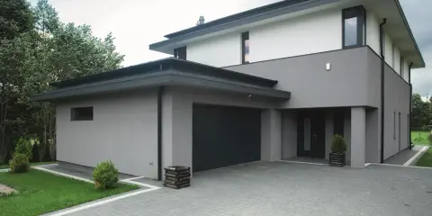 Nowoczesny dom z szarą i białą elewacją, prezentujący najmodniejsze kolory elewacji.