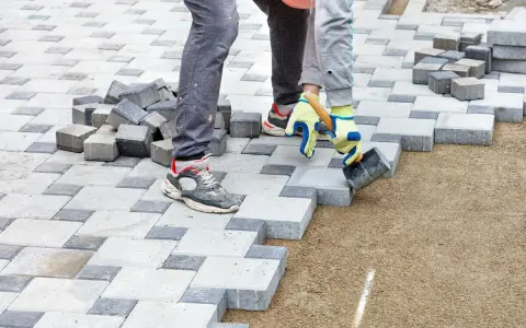 Układanie kostki brukowej na podsypce. Beton pod kostkę tworzy stabilne podłoże dla prac brukarskich.