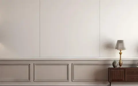 Eleganckie wnętrze z dwoma lampami i komodą. Ściana ozdobiona sztukaterią, przypominającą pionowe lamele, nadaje pomieszczeniu klasyczny charakter.