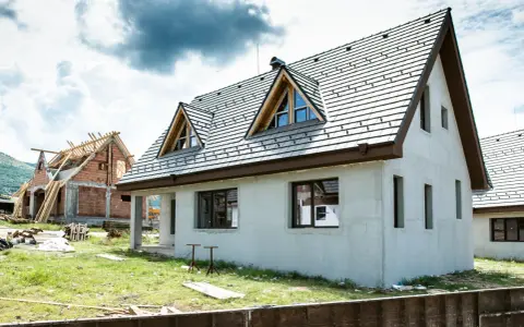 Dwa domy w budowie, jeden z dachem i oknami, drugi w stanie surowym. Idealne miejsce, by zacząć myśleć, jak sprzedać dom.
