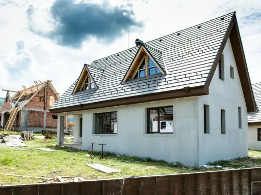 Dwa domy w budowie, jeden z dachem i oknami, drugi w stanie surowym. Idealne miejsce, by zacząć myśleć, jak sprzedać dom.
