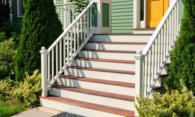Eleganckie schody zewnętrzne z białymi balustradami i drewnianymi stopniami. Inspiracje na schody zewnętrzne, które dodadzą uroku każdemu domowi.