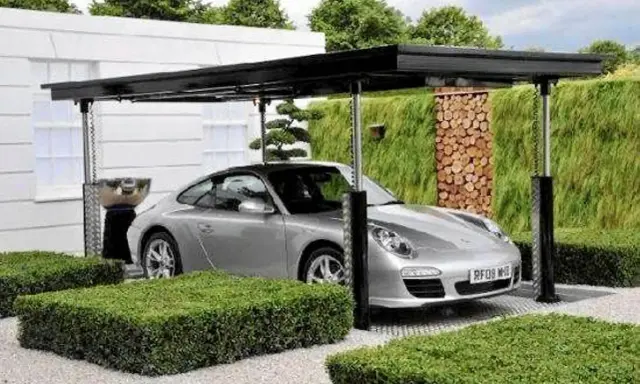Srebrne Porsche pod nowoczesną wiatą, która może być częścią domu z garażem podziemnym.