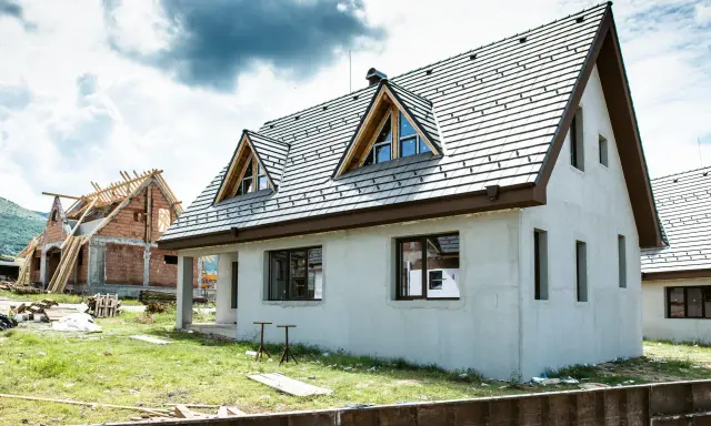 Dwa domy w budowie, jeden z dachem i oknami, drugi w stanie surowym. Idealne miejsce, by zacząć myśleć, jak sprzedać dom.