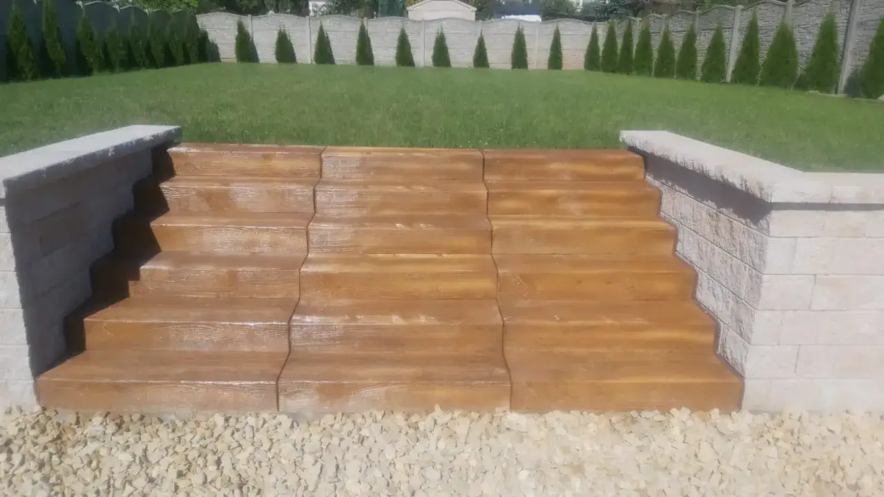 Schody zewnętrzne z efektem drewna, wykonane z betonu dekoracyjnego. Solidne i estetyczne, idealne do ogrodu.
